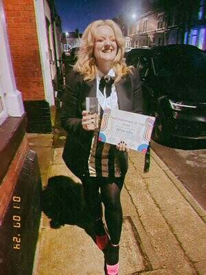 khandie in the street smiling holding her trophy and certificate for winning Rhythm and Poesy Photographer of the Year